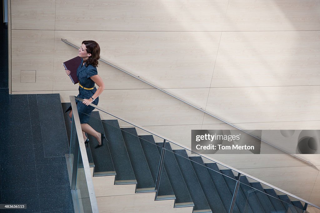 Businesswoman ascending office staircase