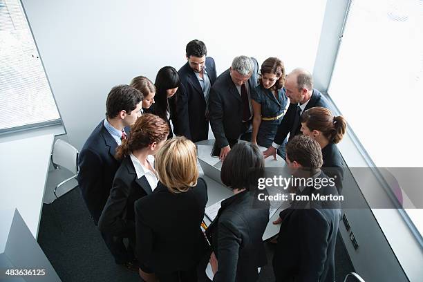 businesspeople gathering in corner of office - bustling office stockfoto's en -beelden