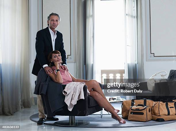 man standing beside of woman sitting on chair  - glamour couple stock pictures, royalty-free photos & images