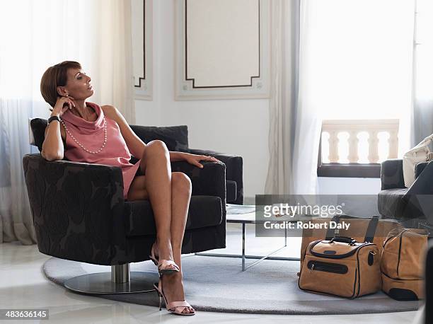 donna con i bagagli seduto in sala d'attesa - vantarsi foto e immagini stock