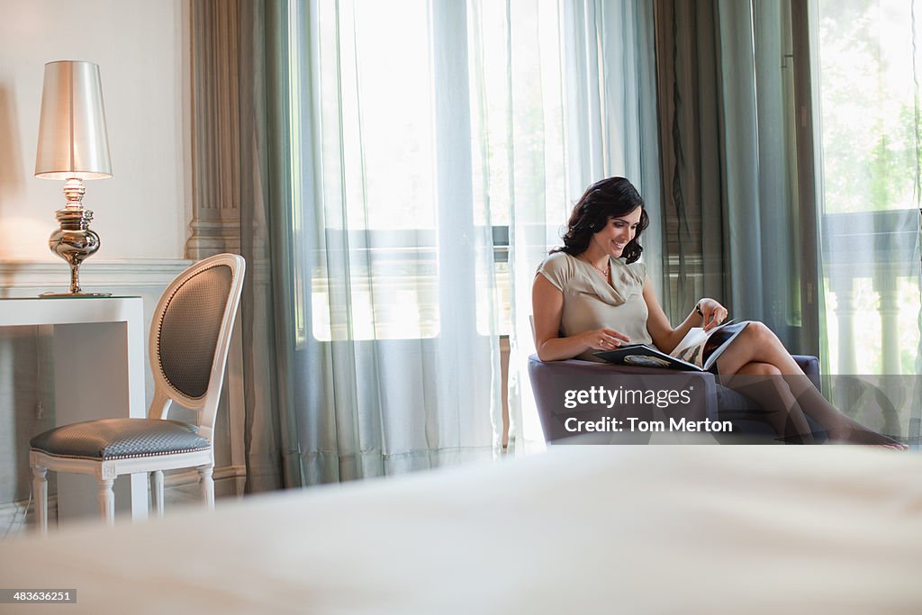Revista de leitura de mulher em Quarto de hotel