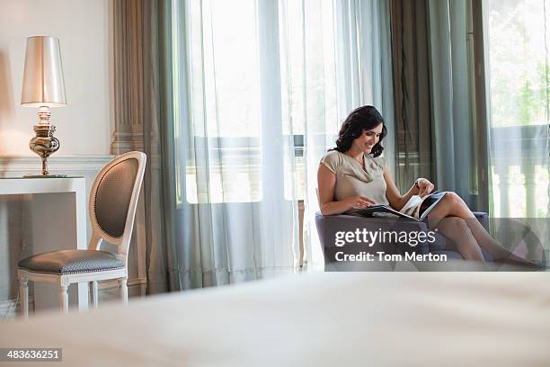 woman reading magazine in hotel room - newspaper luxury bildbanksfoton och bilder