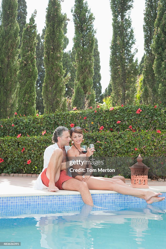 Coppia, bere vino in piscina