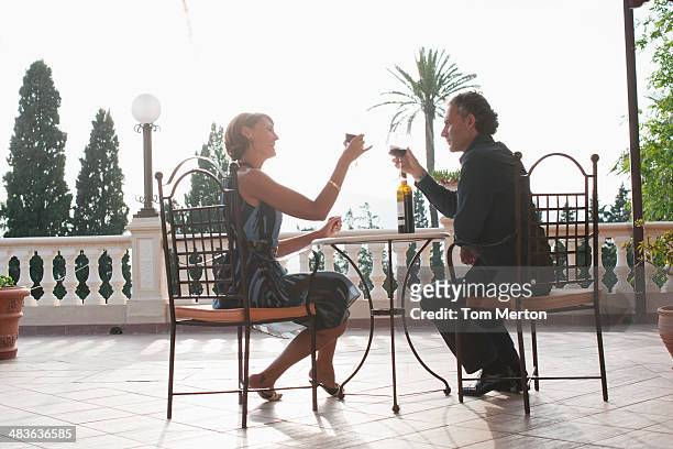 couple having wine on balcony - glamour couple stock pictures, royalty-free photos & images