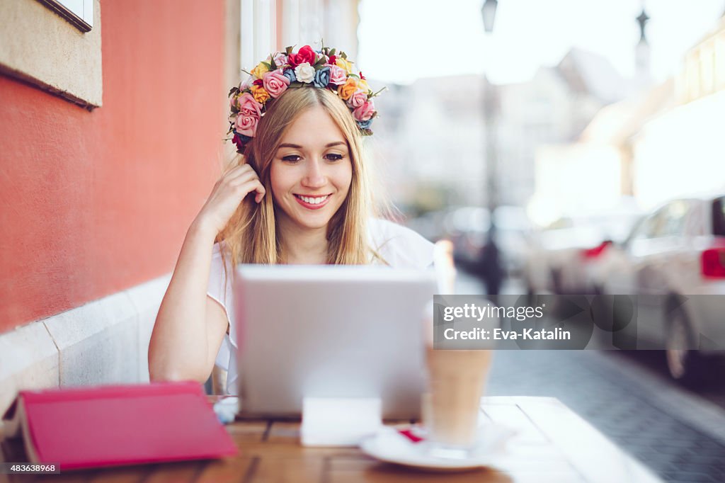 Young woman is reading her tablet in a café