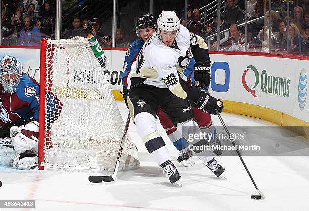 Jayson Megna of the Pittsburgh Penguins skates with the puck while Andre Benoit of the Colorado Avalanche applies pressure at the Pepsi Center on...