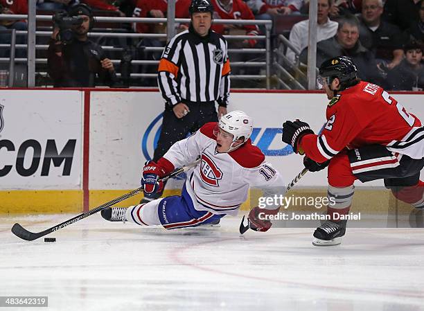 Brendan Gallagher of the Montreal Canadiens hits the ice trying to control the puck under pressure from Duncan Keith of the Chicago Blackhawks at the...
