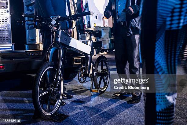 Visitors inspect a Ford MoDe:Me foldable electric e-bike on display during the Ford Motor Co. "Go Further" event at the Sandton Convention Center in...