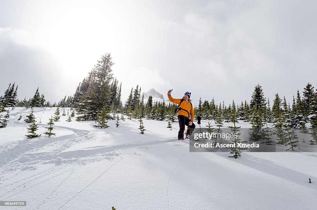 Skier takes selfie picture in mountain landscape