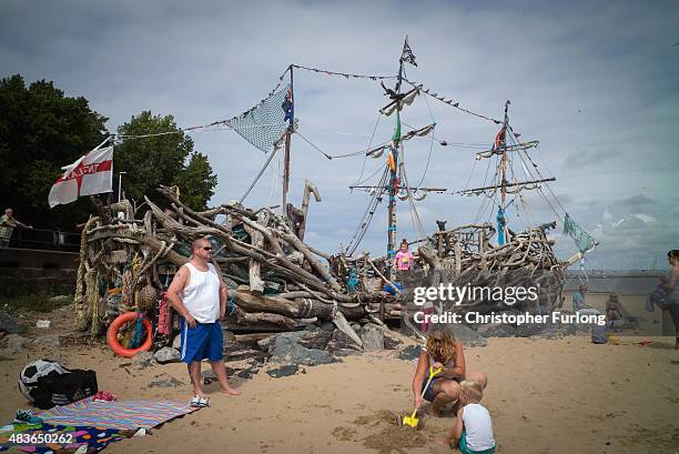 Daytrippers and children on the Summer break from school enjoy the Black Pearl pirate ship art installation, which is made from driftwood, at New...