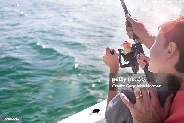 young boy fishing with dad's help - florida angeln stock-fotos und bilder