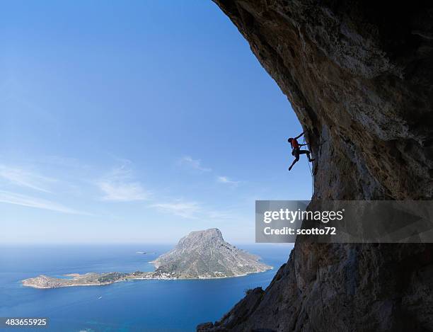 woman rockclimbing silhouette - overhangende rots stockfoto's en -beelden