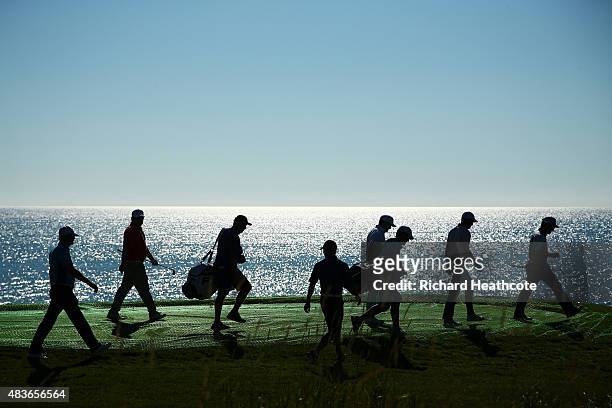 Group of players and caddie leave a tee box during a practice round prior to the 2015 PGA Championship at Whistling Straits on August 11, 2015 in...