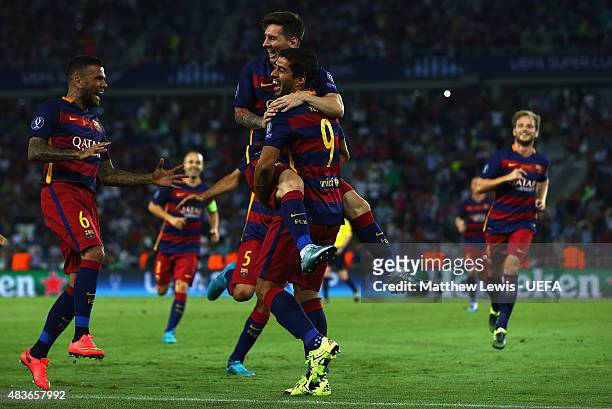 Lionel Messi of Barcelona is congratulated by Luis Suarez, after scoring his second goal by team mates during the UEFA Super Cup between Barcelona...