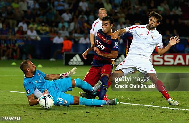 Rafinha of Barcelona scores the third goal under pressure from Beto and Coke of Sevilla during the UEFA Super Cup between Barcelona and Sevilla FC at...