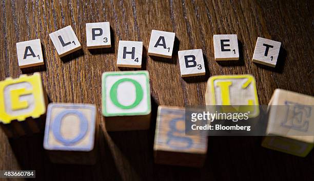 Children's blocks and Hasbro Inc. Scrabble letters spell out the words "Google" and "Alphabet" in this arranged photograph taken in Tiskilwa,...