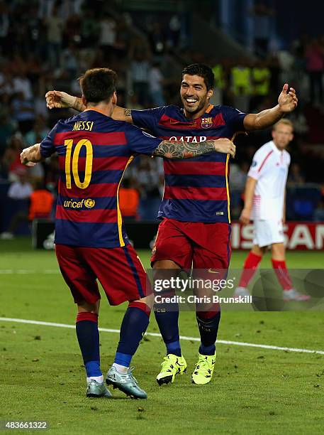 Lionel Messi of Barcelona celebrates with Luis Suarez of Barcelona after Rafinha of Barcelona scored their third goal during the UEFA Super Cup...