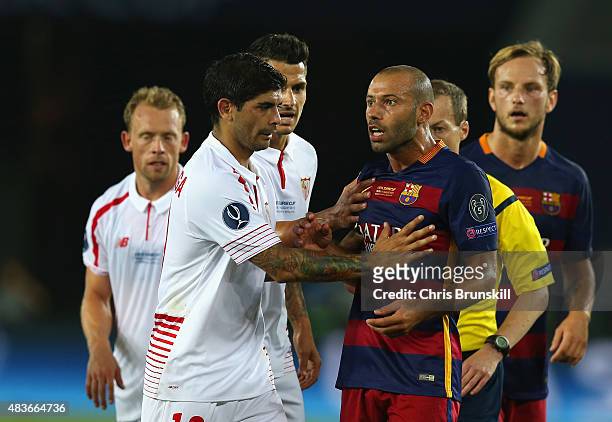 Ever Banega of Sevilla holds back Javier Mascherano of Barcelona during the UEFA Super Cup between Barcelona and Sevilla FC at Dinamo Arena on August...