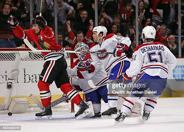 Patrick Sharp of the Chicago Blackhawks celebrates his game-winning goal in overtime in front of Peter Budaj, Mike Weaver and David Desharnais of the...