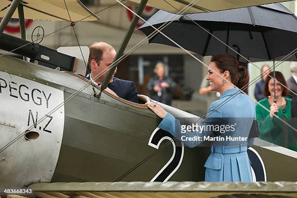 Prince William, Duke of Cambridge sits in a WW1 aircraft as Catherine, Duchess of Cambridge looks on during a visit to Omaka Aviation Heritage Centre...