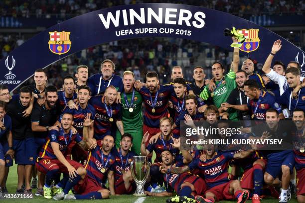 Barcelona's team celebrates with the trophy after winning the UEFA Super Cup final football match between FC Barcelona and Sevilla FC on August 11,...