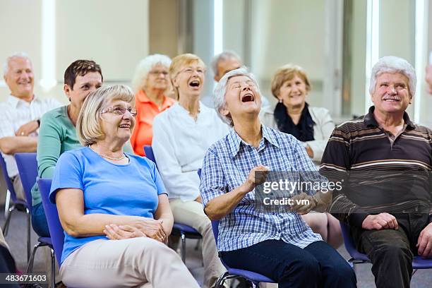 seniors enjoying stage performance - audience laughing stock pictures, royalty-free photos & images