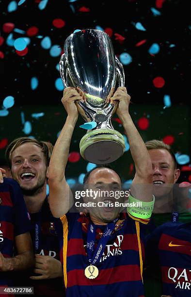 Andres Iniesta of Barcelona lifts the UEFA Cup trophy as Barcelona celebrate victoy during the UEFA Super Cup between Barcelona and Sevilla FC at...