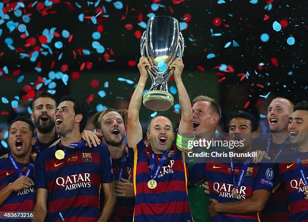 Andres Iniesta of Barcelona lifts the UEFA Cup trophy as Barcelona celebrate victoy during the UEFA Super Cup between Barcelona and Sevilla FC at...