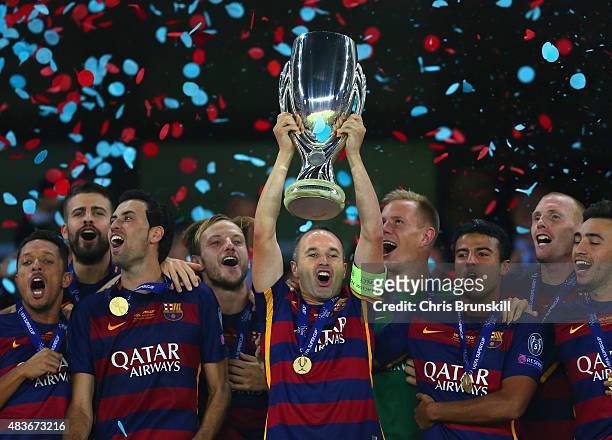 Andres Iniesta of Barcelona lifts the UEFA Cup trophy as Barcelona celebrate victoy during the UEFA Super Cup between Barcelona and Sevilla FC at...