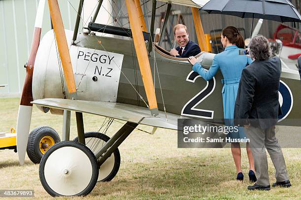 Catherine, Duchess of Cambridge and Sir Peter Jackson look at Prince William, Duke of Cambridge sit in a plane at a WW1 commemorative and Flying Day...