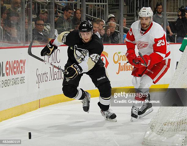 Adam Payerl of the Pittsburgh Penguins skates for the loose puck alongside Brian Lashoff of the Detroit Red Wings on April 9, 2014 at Consol Energy...
