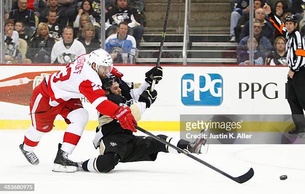 Brian Gibbons of the Pittsburgh Penguins is taken to the ice by Brian Lashoff of the Detroit Red Wings during the game at Consol Energy Center on...