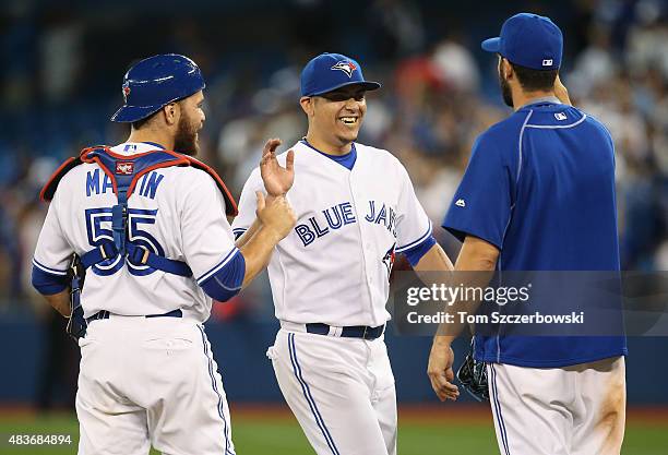 Roberto Osuna of the Toronto Blue Jays celebrates their victory with Russell Martin and Chris Colabello during MLB game action against the Oakland...