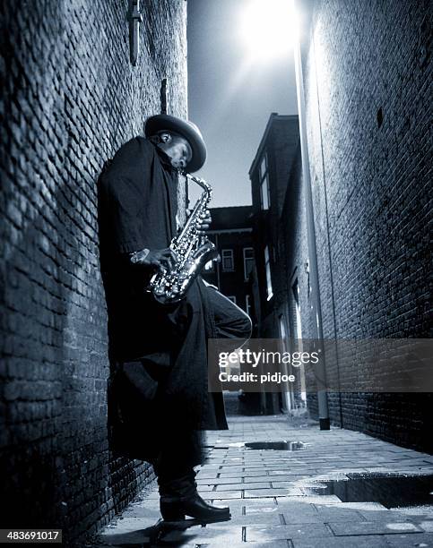 straßenmusiker spielen saxophon in alley - blues music stock-fotos und bilder