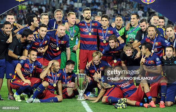 Barcelona's players celebrate with the trophy after winning the UEFA Super Cup final football match between FC Barcelona and Sevilla FC on August 11,...