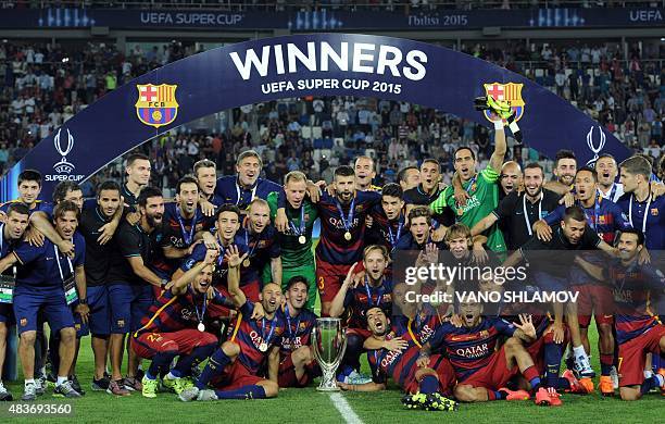 Barcelona's players celebrate with the trophy after winning the UEFA Super Cup final football match between FC Barcelona and Sevilla FC on August 11,...