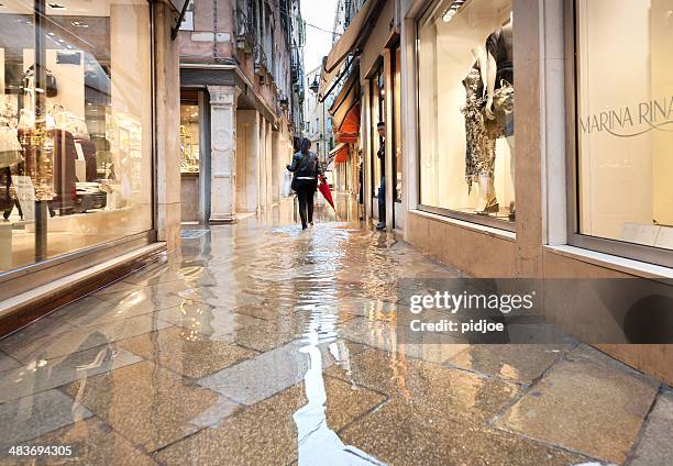 woman with boots walking through flooded alley in venice italy - venice flood 個照片及圖片檔
