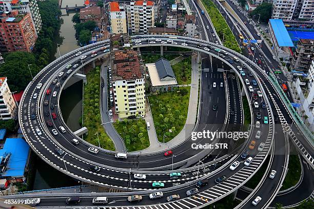 This picture taken on August 11, 2015 shows a "nail house" standing in the middle of a flyover in Guangzhou, south China's Guangdong province. Three...