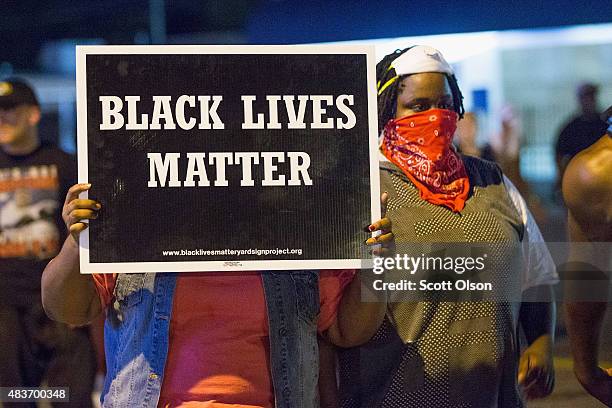 Demonstrators, marking the one-year anniversary of the shooting of Michael Brown, protest along West Florrisant Street on August 10, 2015 in...