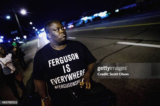 Demonstrators, marking the one-year anniversary of the shooting of Michael Brown, protest along West Florrisant Street on August 11, 2015 in...