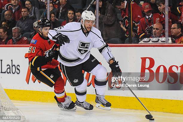 Ken Agostino of the Calgary Flames chases Jake Muzzin of the Los Angeles Kings during an NHL game at Scotiabank Saddledome on April 9, 2014 in...