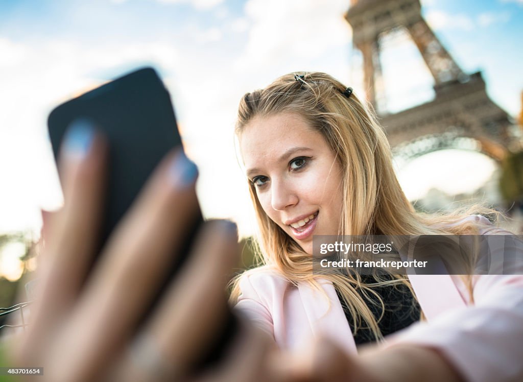 Woman self photographing on paris ith the tour eiffel