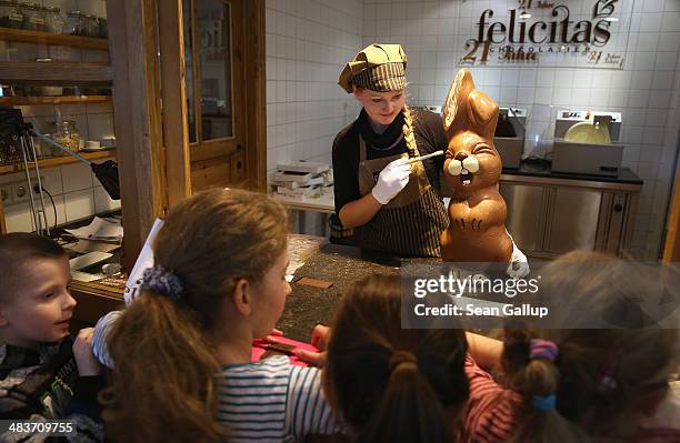 Children from a Polish tour group watch as employee Sandra Jaeckel demonstrates a brush technique on a giant chocolate Easter bunny at Confiserie...