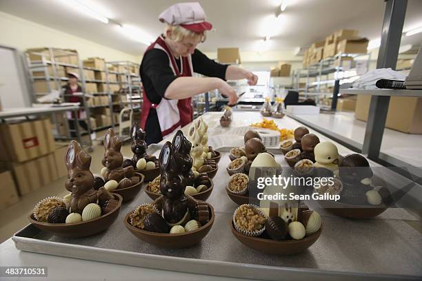 Employee Doreen Krohe packs chocolate Easter bunnies and eggs at the production facility at Confiserie Felicitas chocolates maker on April 9, 2014 in...