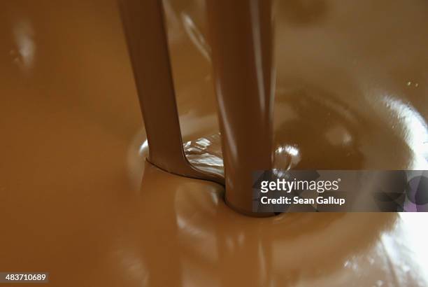 Milk chocolate flows into a vat at the production facility at Confiserie Felicitas chocolates maker on April 9, 2014 in Hornow, Germany. Easter is...