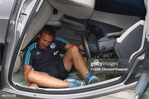 Head coach Andre Breitenreiter climbs out of a turning car during a test drive of Schalke at driving safety centre Rheinberg on August 12, 2015 in...