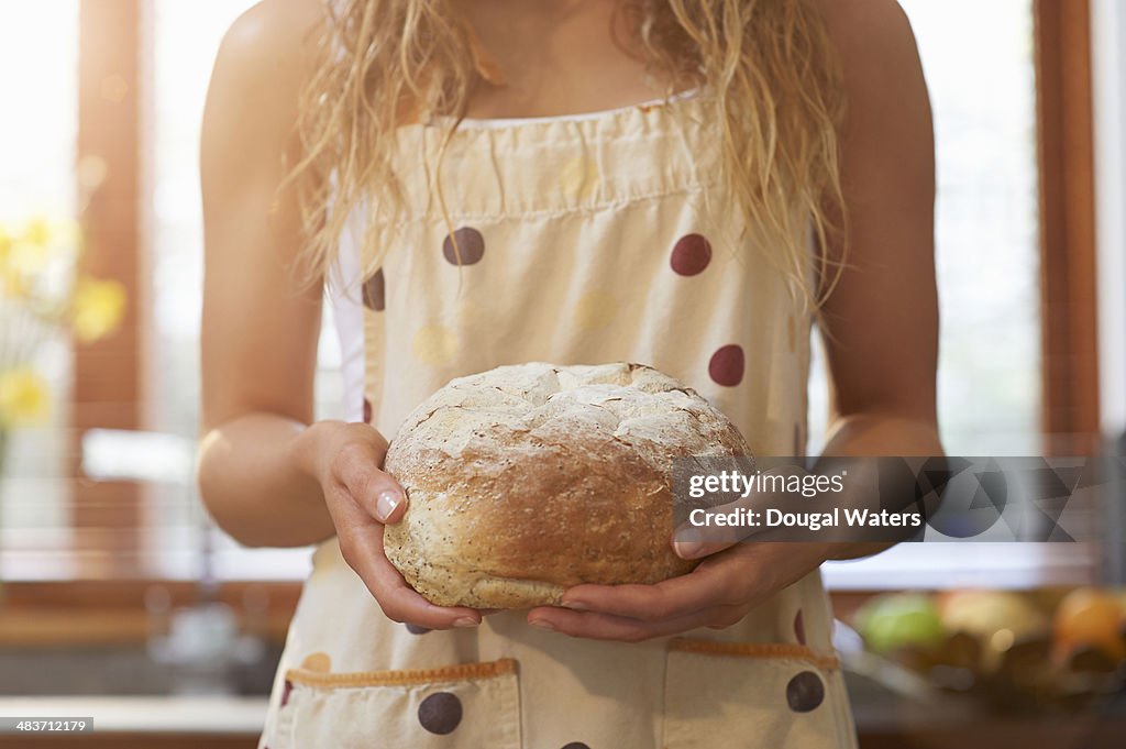 Woman holding freshly baked bread.