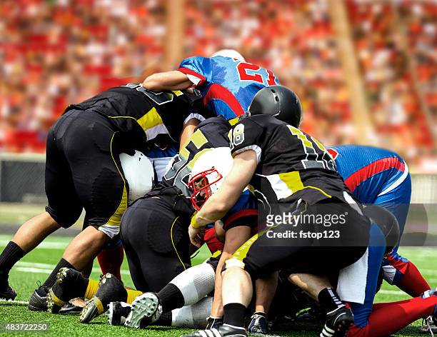 football team tackles running back. defenders. stadium fans. field. - tackling stock pictures, royalty-free photos & images