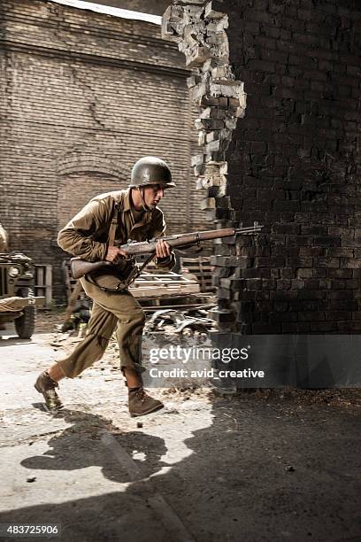 wwii soldier running into building under attack - ww2 soldier stock pictures, royalty-free photos & images