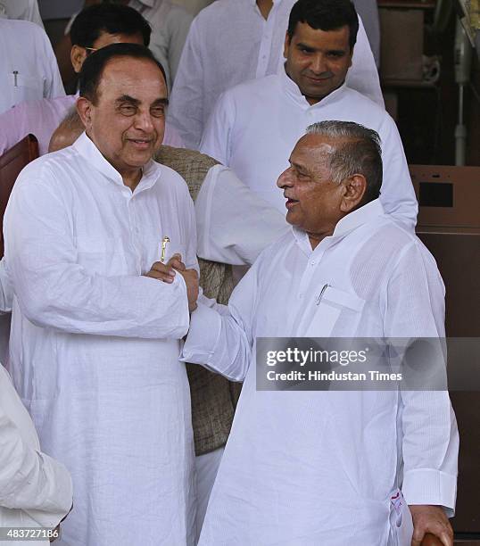 Samajwadi Party supremo Mulayam Singh Yadav talks with BJP leader Subramanian Swamy during the monsoon session at Parliament House, on August 12,...